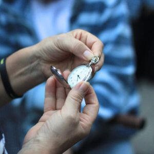 Interaktyvi ekskursija apie žydišką Vilnių iki Antrojo pasaulinio karo. Moteris laiko rankose kišeninį laikordį interaktyvioje ekskursijoje apie žydišką Vilnių iki Antrojo pasaulinio karo,