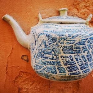 Ekskursija apie senojo Vilniaus virtuvės ir maisto pasakojimus Vilniaus senamiesčio meninis motyvas - keraminikis arbatinis pritvirtintas ant sienos, kuris yra dekoruotas LDK žemėlapiu.